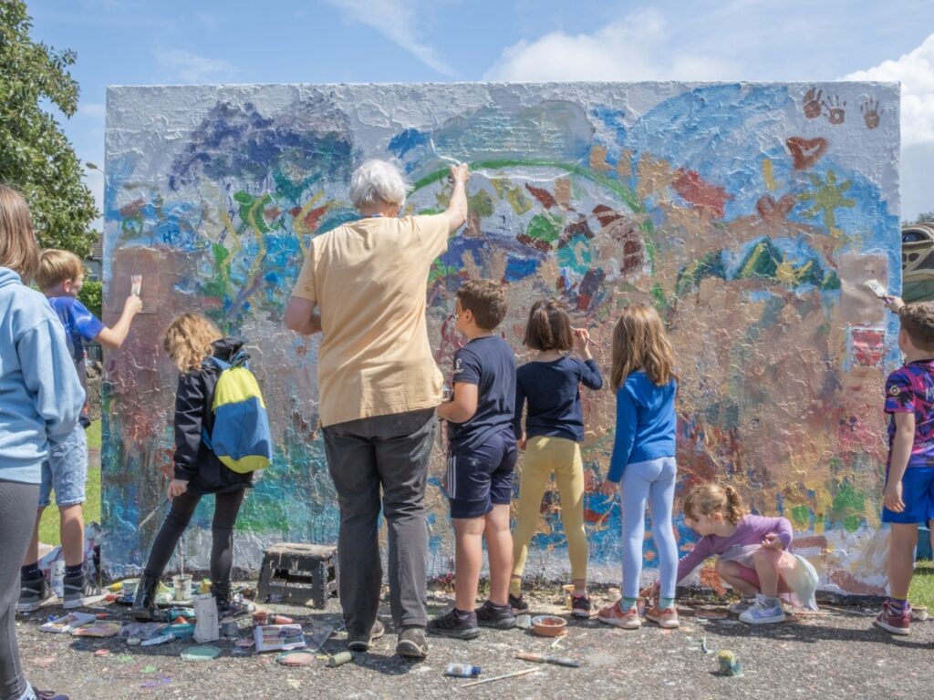 Group of children painting a wall at Frome Children's Festival 2023