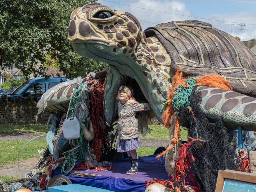 Young girl inside a turtle sculpture at Frome Children's Festival 2023
