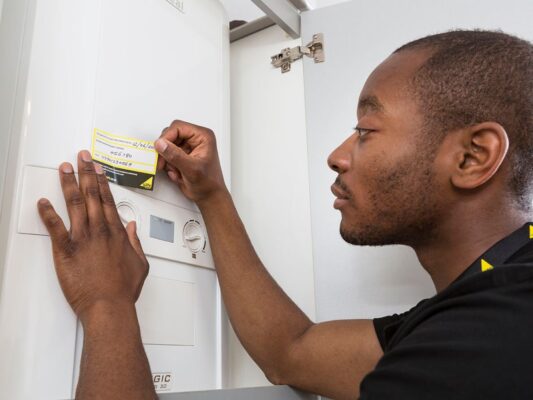 Gas Safe Engineer applying a sticker to a home boiler to show it's gas safe