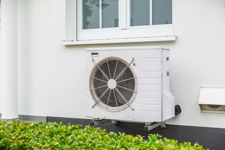 Air source heat pump outside a white house