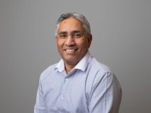 Photo of CEO Mark Mayler looking to camera and smiling, in front of a grey coloured background.