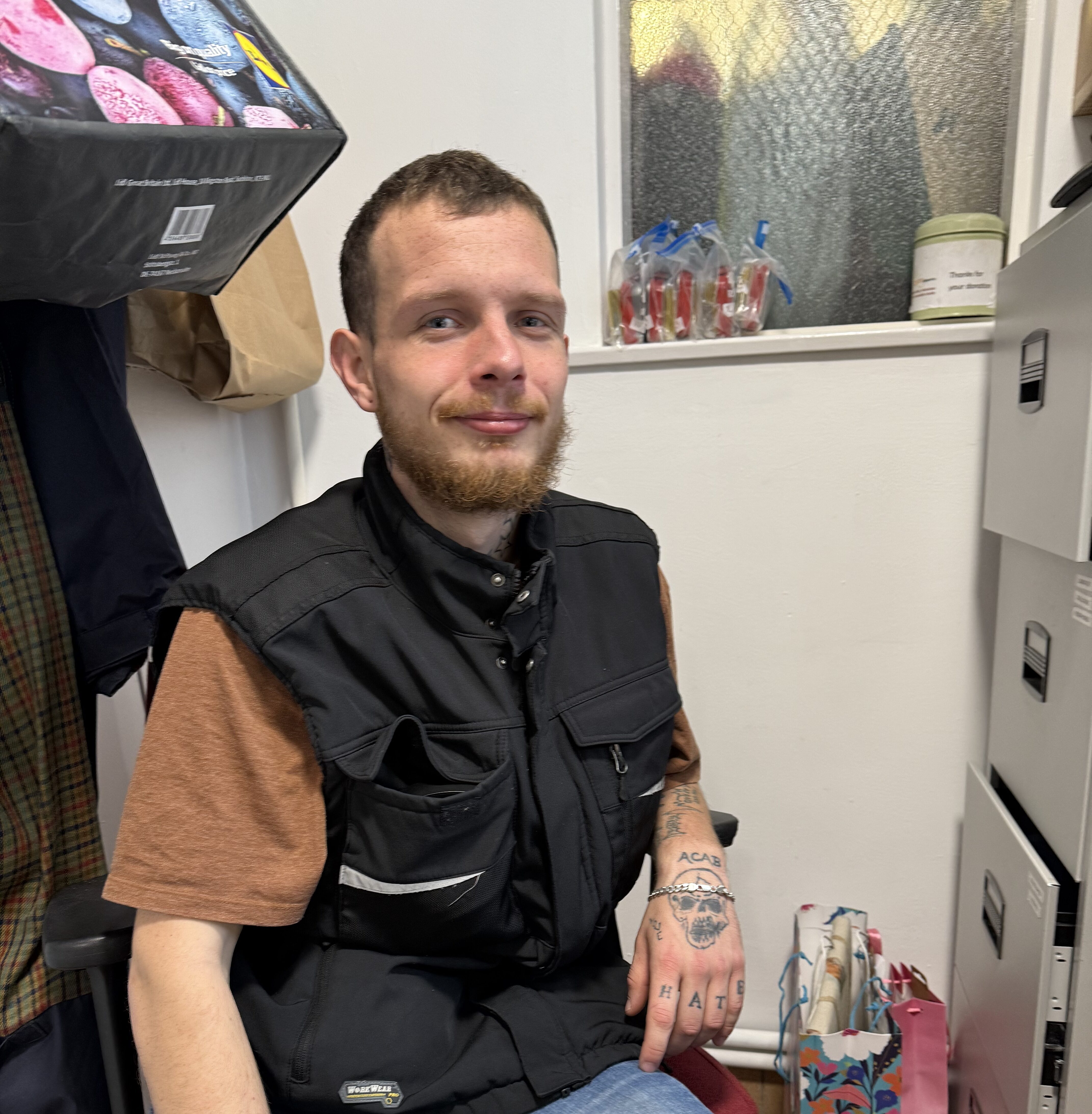 A man sitting in the office of a charity that is providing help and food