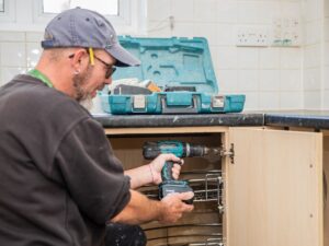 Selwood Housing staff repairing kitchen cupboard