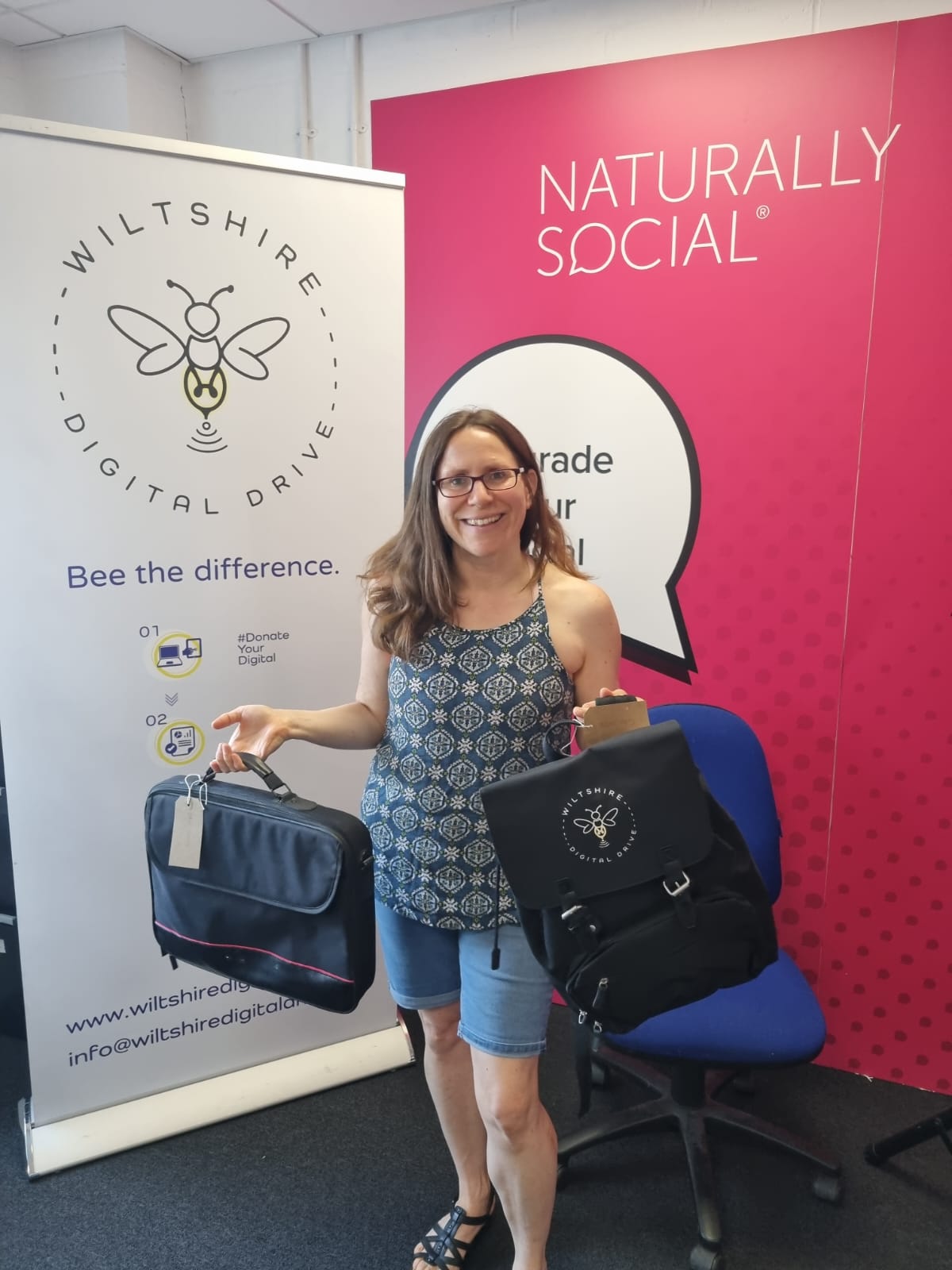 A volunteer from Wiltshire Digital Drive displaying two donated devices