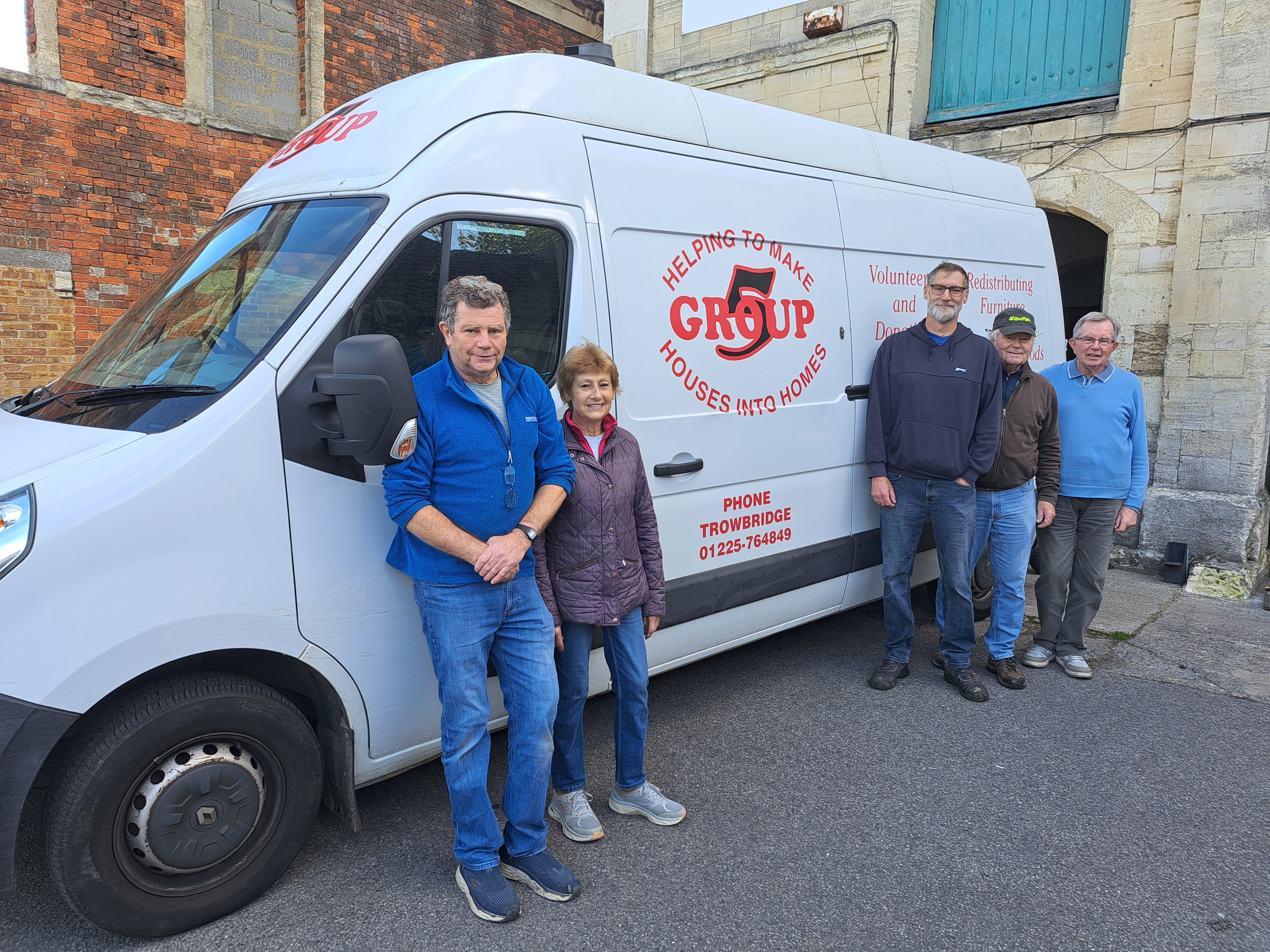 Volunteers stand beside the branded Group 5 van