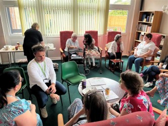 Staff and residents mingle at a summer tea party