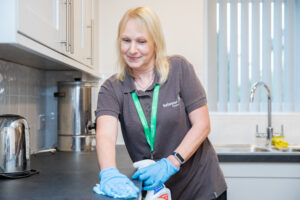 A female caretaker cleaning a communal area.