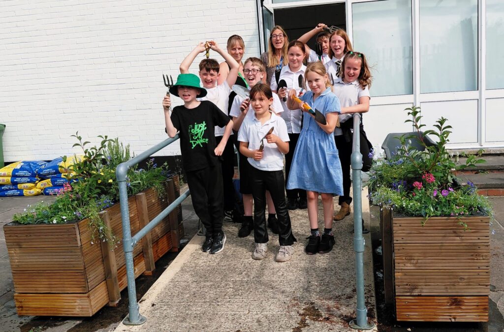 A group of school children from TEAM10 celebrate the project