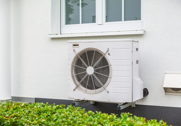 Air source heat pump outside a white house
